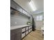 A modern laundry room featuring grey cabinets, black and white tile, new appliances and ample storage at 2388 Oakwood Preserve Dr, Wesley Chapel, FL 33543