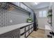 A modern laundry room featuring grey cabinets, black and white tile, new appliances and ample storage at 2388 Oakwood Preserve Dr, Wesley Chapel, FL 33543