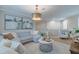 Comfortable living room area with a large sectional, shutters, decor and a decorative coffee table at 2388 Oakwood Preserve Dr, Wesley Chapel, FL 33543