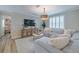 Comfortable living room area with a large sectional, shutters, decor and a decorative coffee table at 2388 Oakwood Preserve Dr, Wesley Chapel, FL 33543