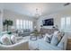 Cozy living room featuring a gray sofa, chairs and a chandelier with window shutters at 2388 Oakwood Preserve Dr, Wesley Chapel, FL 33543