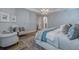 Bright primary bedroom with tray ceiling, modern chandelier, and plantation shutters at 2388 Oakwood Preserve Dr, Wesley Chapel, FL 33543