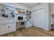 This office features built in shelves, white cabinets, wood floors, a modern desk and a sliding door closet at 2388 Oakwood Preserve Dr, Wesley Chapel, FL 33543
