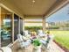 Covered patio features a fire pit, comfortable seating, and a view of the backyard and neighborhood at 2388 Oakwood Preserve Dr, Wesley Chapel, FL 33543