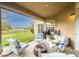 Covered patio features comfortable seating, a fire pit, and a view of the backyard and neighborhood at 2388 Oakwood Preserve Dr, Wesley Chapel, FL 33543