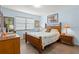 Bedroom with wood floors, a large window, and a wooden bed frame at 2400 Winding Creek Blvd # 4-101, Clearwater, FL 33761