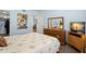Bedroom with wood floors, a dresser with a mirror, and closet access at 2400 Winding Creek Blvd # 4-101, Clearwater, FL 33761