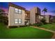 Inviting condo with manicured lawn and lush tropical landscaping at sunset at 2400 Winding Creek Blvd # 4-101, Clearwater, FL 33761