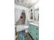 Bathroom features floral wallpaper, a tub with shower, and an aqua vanity at 2475 Bay Berry Dr, Clearwater, FL 33763