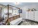 Bedroom features a gold-framed four-poster bed, white dresser, and a stylish area rug at 2475 Bay Berry Dr, Clearwater, FL 33763