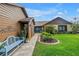 Charming home featuring a well-manicured lawn, lush landscaping, and inviting entryway with a comfortable, light blue bench at 2475 Bay Berry Dr, Clearwater, FL 33763