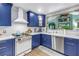 Bright kitchen featuring white counters, stainless steel appliances, and custom blue cabinetry at 2475 Bay Berry Dr, Clearwater, FL 33763