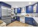 Updated kitchen showcasing stainless steel appliances, custom blue cabinetry, and updated countertops at 2475 Bay Berry Dr, Clearwater, FL 33763