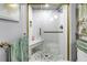 Walk-in shower featuring white textured tile, glass door, and a built-in seat at 2475 Bay Berry Dr, Clearwater, FL 33763