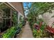 Picturesque side yard with a pathway lined with verdant plants and a cozy sitting area at 2475 Bay Berry Dr, Clearwater, FL 33763