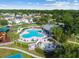 Aerial view shows the community pool area with lounge chairs, umbrellas, and a spa at 25521 Bruford Blvd, Land O Lakes, FL 34639