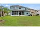 A two-story home featuring a screened-in lanai and lush backyard at 25521 Bruford Blvd, Land O Lakes, FL 34639