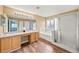Bathroom with double vanity, soaking tub, and separate glass-enclosed shower at 25521 Bruford Blvd, Land O Lakes, FL 34639