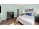 This cozy bedroom offers hardwood floors, a queen bed, and modern decor at 25521 Bruford Blvd, Land O Lakes, FL 34639