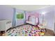 Colorful bedroom with a canopy bed, soft chair, colorful rug and natural light at 25521 Bruford Blvd, Land O Lakes, FL 34639