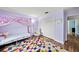 Bright bedroom featuring a canopy bed, chair, closet and colorful rug at 25521 Bruford Blvd, Land O Lakes, FL 34639