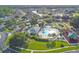 A beautiful community pool area features a unique shape, palm trees, lounge chairs, and a hot tub with a clubhouse nearby at 25521 Bruford Blvd, Land O Lakes, FL 34639