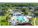 Aerial view showcases a community pool area with lounge chairs, umbrellas, palm trees, and a hot tub in a well-maintained neighborhood at 25521 Bruford Blvd, Land O Lakes, FL 34639