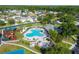 Aerial view highlights a community pool area with a unique shape, lounge chairs, palm trees, and a nearby playground at 25521 Bruford Blvd, Land O Lakes, FL 34639