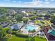 Aerial view displays a community pool area with palm trees, lounge chairs, hot tub, playground, and a nearby basketball court at 25521 Bruford Blvd, Land O Lakes, FL 34639