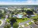 Aerial view showcases a beautiful community pool, playground, and scenic lakes surrounded by lush trees in a charming neighborhood at 25521 Bruford Blvd, Land O Lakes, FL 34639