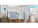 Second-floor hallway with wood floors and contemporary blue and white decor at 25521 Bruford Blvd, Land O Lakes, FL 34639