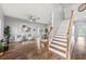 Open-concept living room with wood floors, modern decor, and staircase at 25521 Bruford Blvd, Land O Lakes, FL 34639