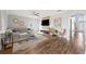 Open-concept living room featuring wood floors, large sectional, and modern decor at 25521 Bruford Blvd, Land O Lakes, FL 34639