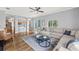 Bright living room area leading into a kitchen area with modern ceiling fan at 25521 Bruford Blvd, Land O Lakes, FL 34639