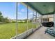 Enclosed patio with outdoor seating overlooking a well-maintained lawn and pond at 25521 Bruford Blvd, Land O Lakes, FL 34639