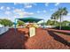 Community playground with covered play structure and soft mulch ground cover at 25521 Bruford Blvd, Land O Lakes, FL 34639