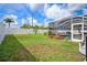 The backyard features a screened lanai with a pool, surrounded by lush green grass, and a white vinyl fence at 2814 Duncan Tree Cir, Valrico, FL 33594