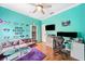 This bedroom features a turquoise accent wall, hardwood floors, decor and an office space at 2814 Duncan Tree Cir, Valrico, FL 33594