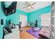Colorful bedroom with a desk area, sofa, and a ceiling fan, providing comfort and functionality at 2814 Duncan Tree Cir, Valrico, FL 33594
