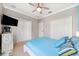 Bedroom features a queen-size bed, and a mounted TV, with a ceiling fan at 2814 Duncan Tree Cir, Valrico, FL 33594