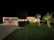 Night view of a home with a manicured lawn, trimmed hedges and an attached three-car garage at 2814 Duncan Tree Cir, Valrico, FL 33594