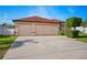 Exterior view of a three-car garage with a concrete driveway and manicured landscaping at 2814 Duncan Tree Cir, Valrico, FL 33594