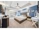 A view of the main bedroom, complete with a ceiling fan, tray ceiling, carpet, and tufted headboard at 2814 Duncan Tree Cir, Valrico, FL 33594