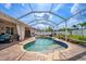Relaxing pool featuring a sun shelf and blue tile accents inside of a screened enclosure with string lights at 2814 Duncan Tree Cir, Valrico, FL 33594