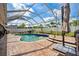 Serene pool within a screened enclosure, complemented by a brick patio and vibrant greenery at 2814 Duncan Tree Cir, Valrico, FL 33594