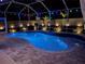 Inviting screened pool area with multicolored lights and brick pavers for outdoor entertaining at 2814 Duncan Tree Cir, Valrico, FL 33594