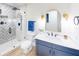 Modern bathroom features a large shower, blue vanity with white countertop, and gold mirror at 2933 Stearns Rd, Valrico, FL 33596