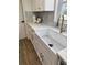 Farmhouse sink with white cabinets, stone countertops, and elegant brass hardware at 2933 Stearns Rd, Valrico, FL 33596