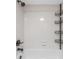 Clean bathroom bathtub featuring a shower head and metal shelving for organization at 3002 W Cleveland St # D4, Tampa, FL 33609