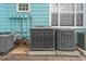 Multiple air conditioning units sit against a light blue building with white trim and a few windows at 3002 W Cleveland St # D4, Tampa, FL 33609